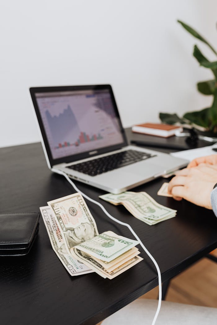Money and laptop on desk indicating financial work or analysis. Perfect for business themes.